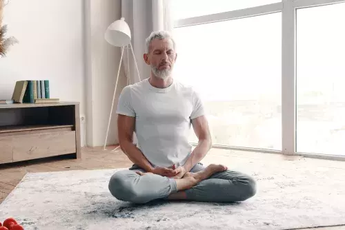 senior man in sport clothing meditating
